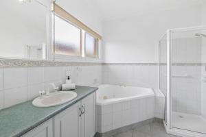 y baño blanco con lavabo y bañera. en On the doorstep of Torquays cafes and beaches, en Torquay