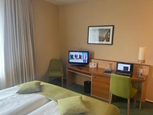 een hotelkamer met een bed en een bureau met een computer bij Atrium Hotel Krüger in Rostock