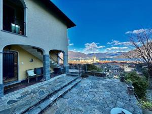 una casa con un banco en un patio de piedra en Amazing view lago maggiore, en Cannobio