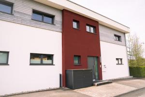 un bâtiment rouge et blanc avec une porte noire dans l'établissement Apartments Verde, à Grein