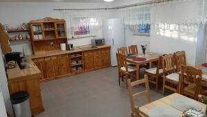 a kitchen with a table and chairs and a refrigerator at Dworek pod świerkami in Jelenia Góra