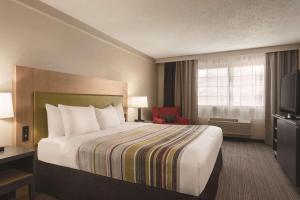 Country Inn & Suites by Radisson, Chicago-Hoffman في هوفمان استيتس: غرفه فندقيه سرير وتلفزيون