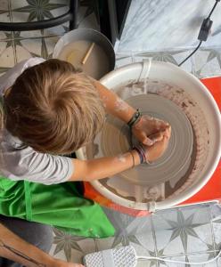 Una donna sta lavorando su una ruota di ceramica di 19 Tile Ceramic Concept - by Unlock Hotels a Caldas da Rainha