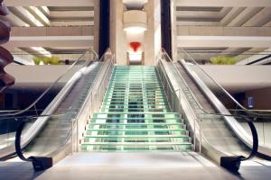 un escalier roulant dans un bâtiment avec des escaliers verts dans l'établissement Hyatt Regency O'Hare Chicago, à Rosemont