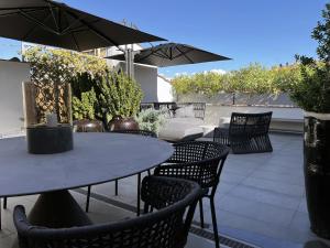 un patio con mesa, sillas y sombrilla en Porta Nera Private Living - adults only, en Florencia