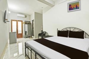 1 dormitorio con 1 cama blanca grande y 1 silla en Hotel O Pravin Guest House, en Goa