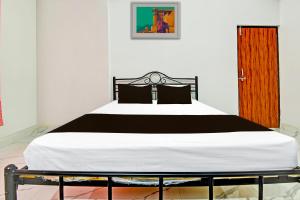 1 dormitorio con 1 cama con edredón blanco y negro en Hotel O Pravin Guest House, en Goa