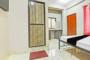 1 dormitorio con cama y ventana grande en Hotel O Pravin Guest House, en Goa