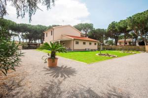 una casa con una pianta in vaso nel vialetto di Casale Lorenzo Appartamenti a Orbetello