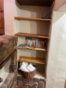 a book shelf with books and a basket at Bello Atardecer in Tilcara