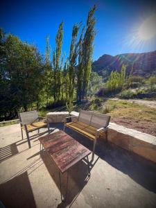 two benches and a table with a view of a mountain at Bello Atardecer in Tilcara