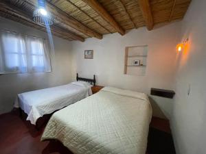 a room with two beds and a window at Bello Atardecer in Tilcara