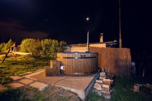 un grand tonneau en bois dans une cour la nuit dans l'établissement Casa City View, à Sibiu