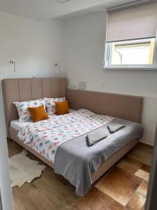 1 dormitorio con 1 cama grande con almohadas de color naranja en Ravne Energy Apartments, en Visoko