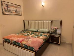 um pequeno quarto com uma cama e um espelho em Holidazzle Villa em Karachi