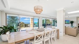 ein Esszimmer mit einem großen Holztisch und Stühlen in der Unterkunft Unit 26 - 3 Bedroom Premier Ocean View in Terrigal