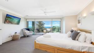 ein Schlafzimmer mit einem großen Bett und einem großen Fenster in der Unterkunft Unit 26 - 3 Bedroom Premier Ocean View in Terrigal