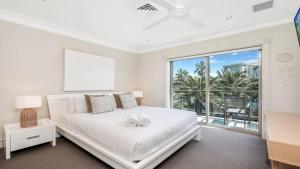 ein Schlafzimmer mit einem weißen Bett und einem großen Fenster in der Unterkunft Unit 26 - 3 Bedroom Premier Ocean View in Terrigal