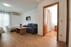 uma sala de estar com um sofá e uma mesa em Studio & Apartments More em Neum