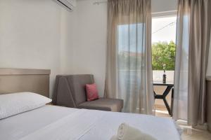 um quarto com uma cama, uma cadeira e uma janela em Studio & Apartments More em Neum