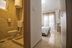 uma casa de banho com WC e uma cama num quarto em Studio & Apartments More em Neum