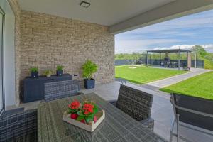 een patio met een tafel en stoelen en een tuin bij Villa Tea in Umag