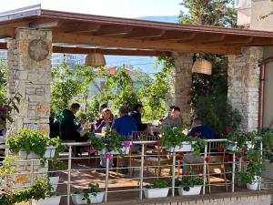 un gruppo di persone seduti in un ristorante sotto un pergolato di Arial Trinity Suites a Vlorë