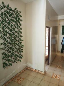 een kamer met een plant aan de muur bij Mona Lisa Guest House, Kisumu in Kisumu