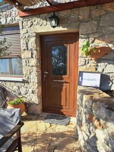 Casa de piedra con puerta de madera en la parte delantera en Ηλιοβασίλεμα, en Chios