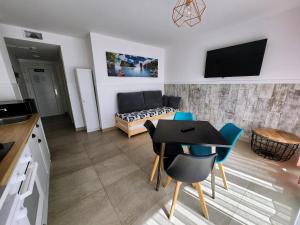 uma cozinha e uma sala de estar com mesa e cadeiras em Apartamentos Playa De Covachos em Soto de la Marina