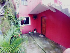 un bâtiment rouge avec un mur rouge et une porte dans l'établissement Casa do Aventureiro, à Abraão