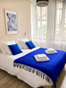 a large bed with blue and white pillows on it at Beau T3 lumineux : La Couronne in Rochefort