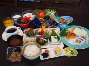 une table recouverte de assiettes et de bols de nourriture dans l'établissement Hotel Sunroute Fukushima, à Fukushima