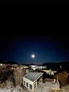 a house at night with the moon in the sky at Aurora dream in Skjervøy