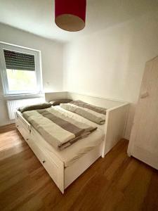 een wit bed in een kamer met een raam bij Ferienwohnung am Wartturm in Besigheim