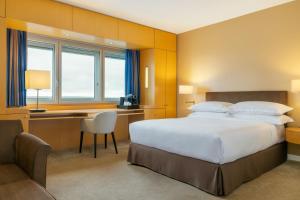 Sheraton Paris Charles de Gaulle Airport Hotel في رواسي أون فرانس: غرفة نوم بسرير ومكتب وكرسي