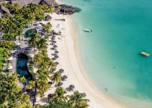 an aerial view of a beach with palm trees and a boat at Royal Palm Beachcomber Luxury in Grand Baie