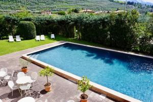 - une piscine dans une cour avec des chaises et des tables dans l'établissement Hotel Diana, à Riva del Garda