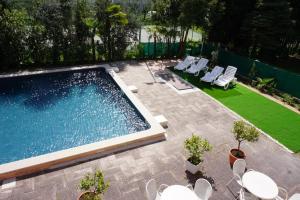 une cour avec une piscine entourée de chaises et d'une pelouse dans l'établissement Hotel Diana, à Riva del Garda