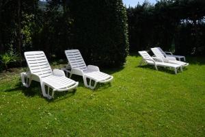 une rangée de chaises longues assises dans l'herbe dans l'établissement Hotel Diana, à Riva del Garda