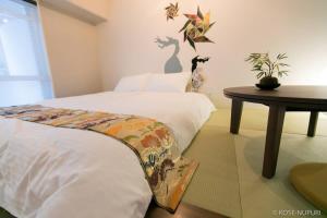 una camera con letto e tavolo con cuscino di bHOTEL Origaminn 303 - 5 mins PeacePark a Hiroshima