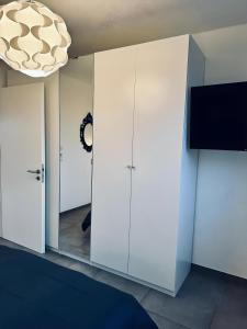 a bedroom with white cabinets and a mirror at FeWo Am Povelturm - mit Aufzug und großer Loggia in Nordhorn