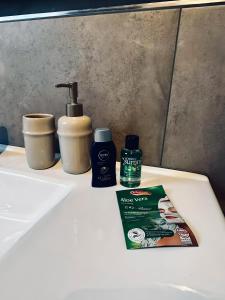 a bathroom sink with a bottle of air freshener and toothpaste at FeWo Am Povelturm - mit Aufzug und großer Loggia in Nordhorn