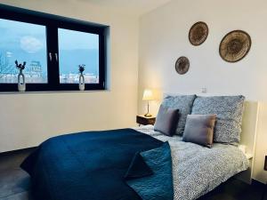 a bedroom with a blue bed and a window at FeWo Am Povelturm - mit Aufzug und großer Loggia in Nordhorn