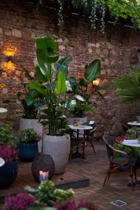 um pátio com mesas e vasos de plantas e cadeiras em Balthazar Design Hotel na Cracóvia