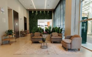 un hall avec des chaises et des plantes dans un bâtiment dans l'établissement eSuites Belo Horizonte Minascasa, à Belo Horizonte