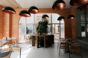 un restaurant avec des tables, des chaises et des lampes suspendues dans l'établissement eSuites Belo Horizonte Minascasa, à Belo Horizonte