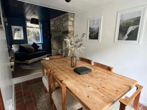 een eetkamer met een houten tafel en een bank bij Terfyn Cottage in Dinorwic