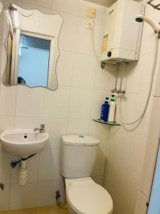 bagno bianco con servizi igienici e lavandino di Johnson Hostel a Hong Kong