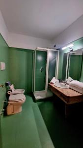 baño verde con 2 lavabos y ducha en Botanique Hotel Vergani, en Fara Gera dʼAdda